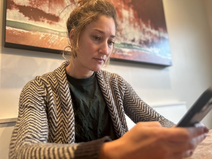 Une photo de Laurence Arena-Daigle regardant des messages sur son cellulaire. 