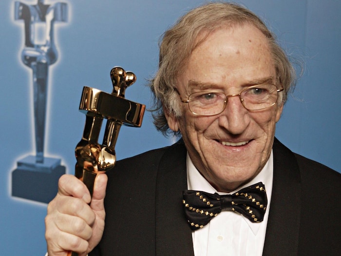 Jean Lapointe sourit et montre son trophée.