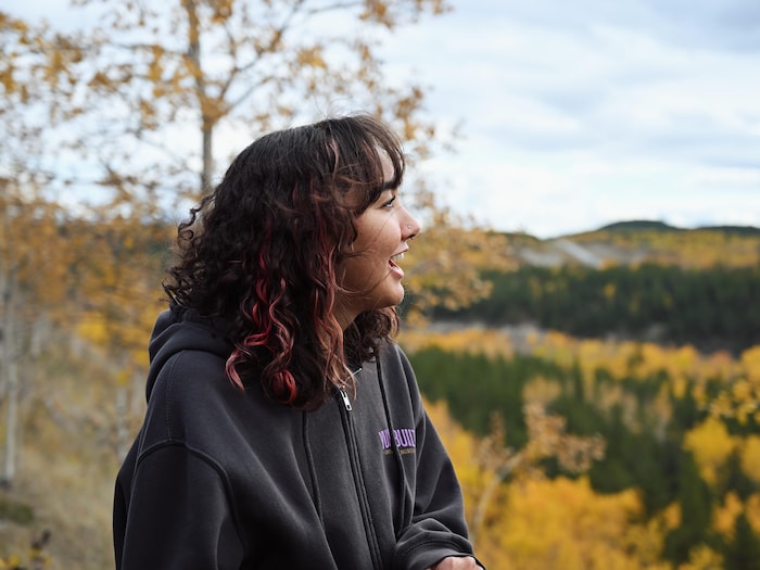 Leandrea regarde l'horizon, au sommet d'une montagne.