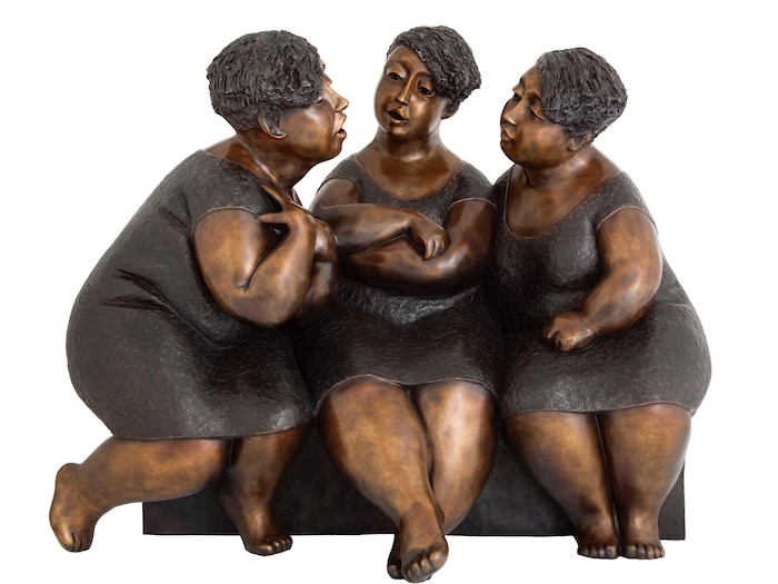 Une sculpture de trois femmes qui discutent sur un banc.