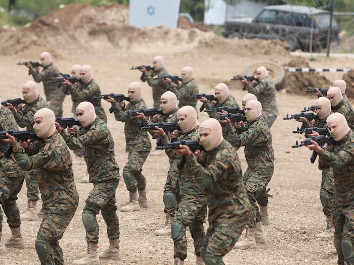 Des soldats cagoulés pointent leurs mitraillettes lors d'un exercice militaire.