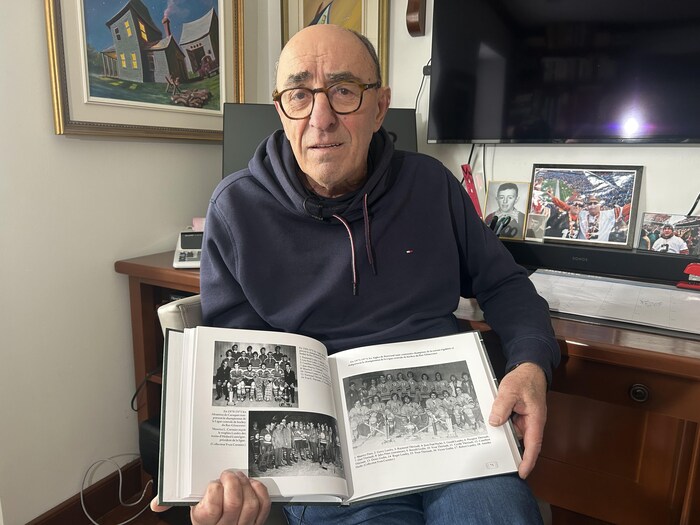 Clarence LeBreton tient un livre ouvert.
