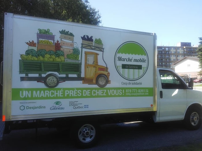 Un camion arborant un logo et une mention disant "Un marché près de chez vous!"