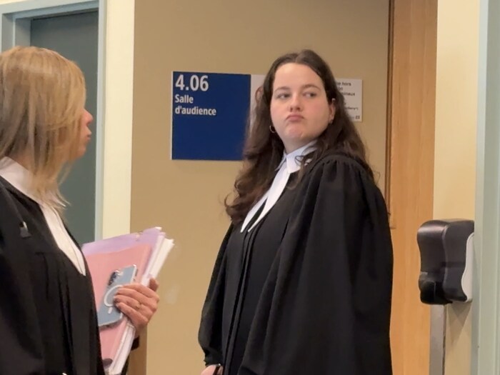 L'avocate portant la toge devant la salle d'audience
