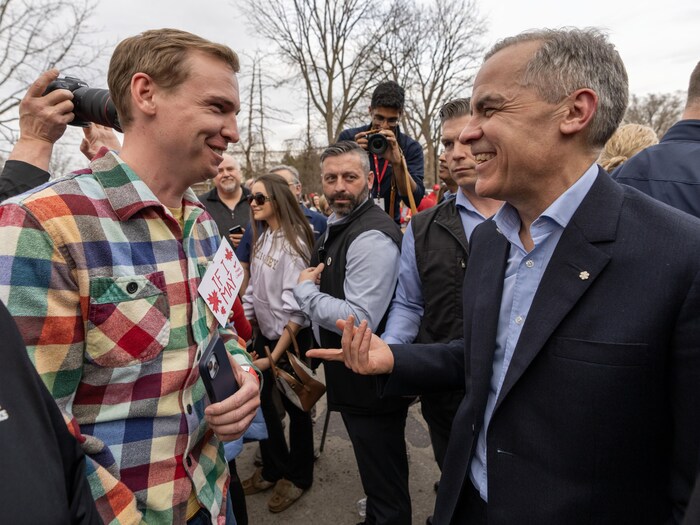 Mark Carney parle avec un homme. 