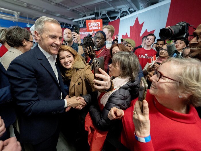 Le chef libéral Mark Carney salue ses partisans.