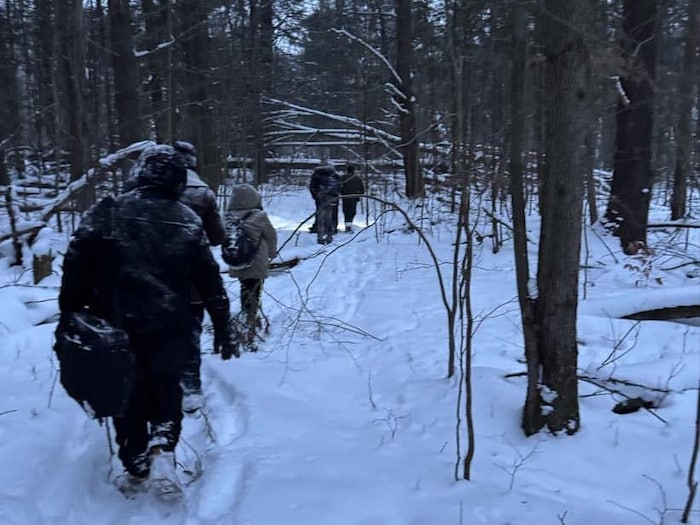 Des migrants marchent dans la neige.