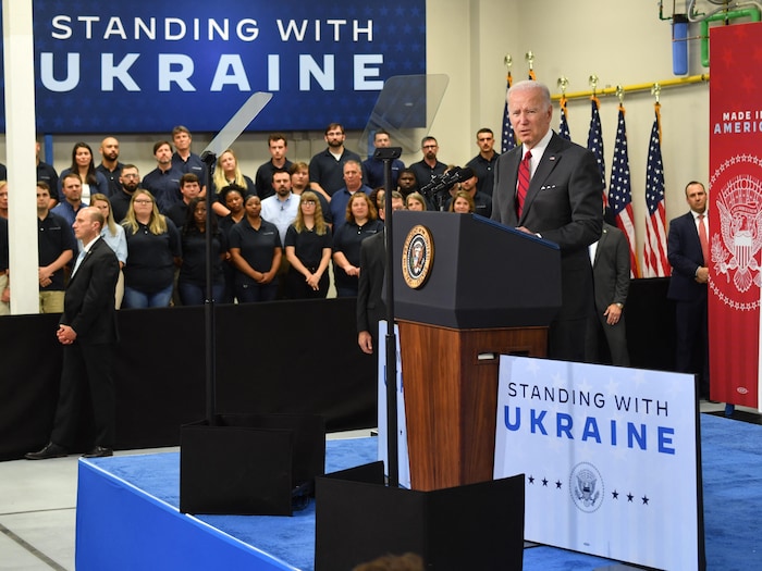 Joe Biden parle devant des panneaux sur lesquels est écrit « Nous nous tenons avec l'Ukraine ».