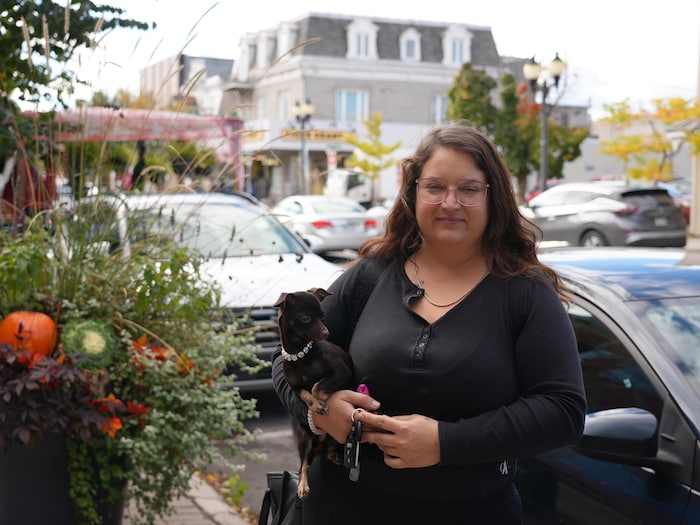 Madame Samson et son petit chien noir posent devant le boulevard de L'Ange-Gardien.