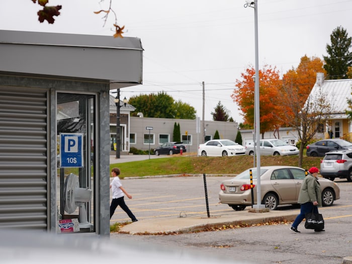 Stationnement avec deux marcheurs et une cabine d'information.