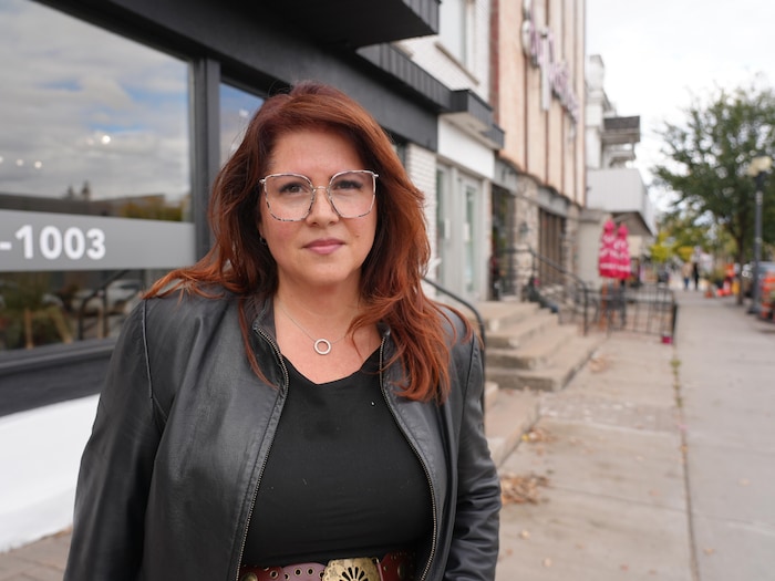 La femme pose devant son salon de coiffure du boulevard de l'Ange-Gardien.