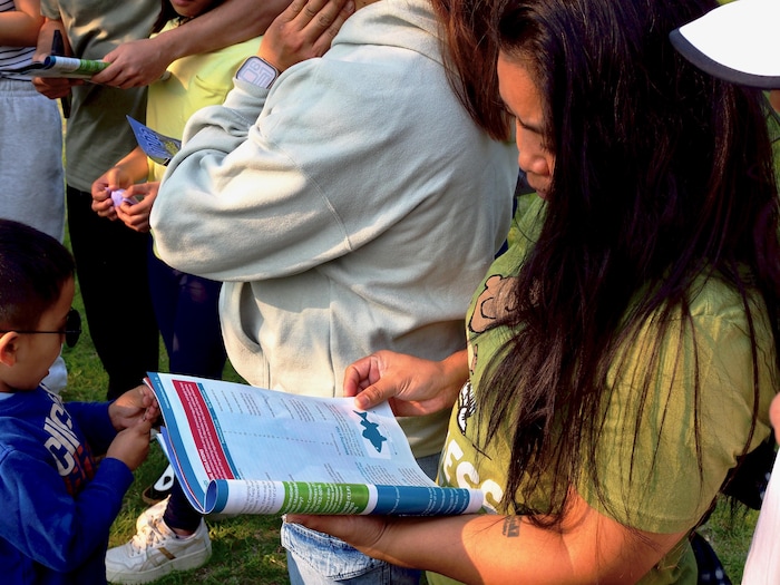 Une femme feuillette une brochure concernant les règles de pêche.