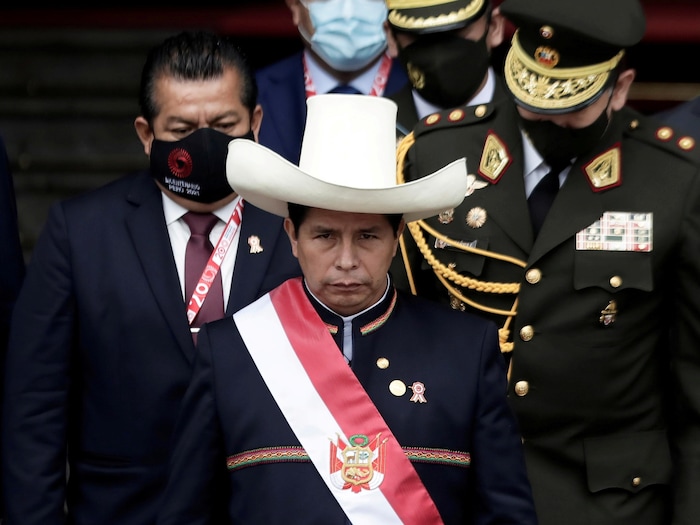 Un homme portant un grand chapeau lors d'une cérémonie protocolaire.