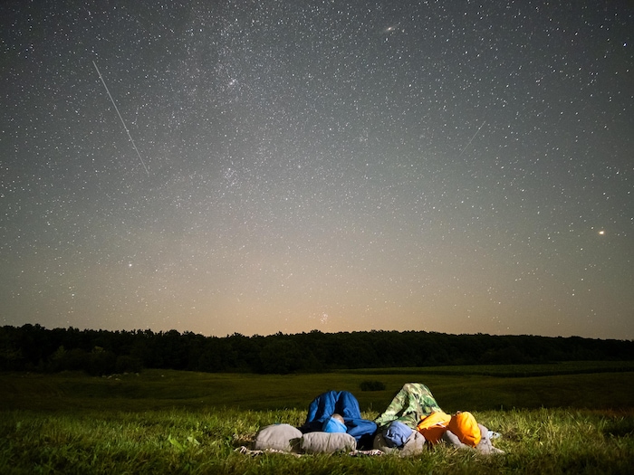 As pessoas notam um céu escuro cheio de estrelas brilhantes.