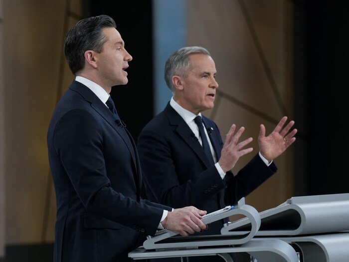 Les deux hommes parlent sur le plateau du débat.