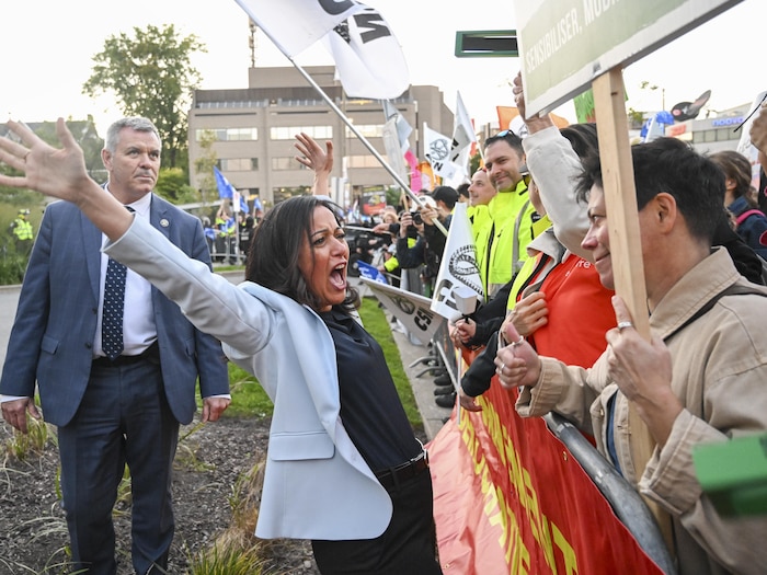 Ruba Ghazal, les bras ouverts, salue avec enthousiasme des partisans rassemblés derrière une barrière.