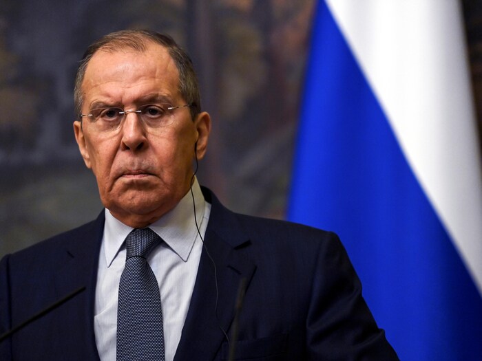 M. Lavrov à côté d'un drapeau russe.