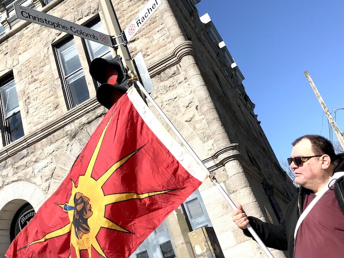 A man holds a flag on rue Christopher Columbus. amherst soon definitively striped montreal