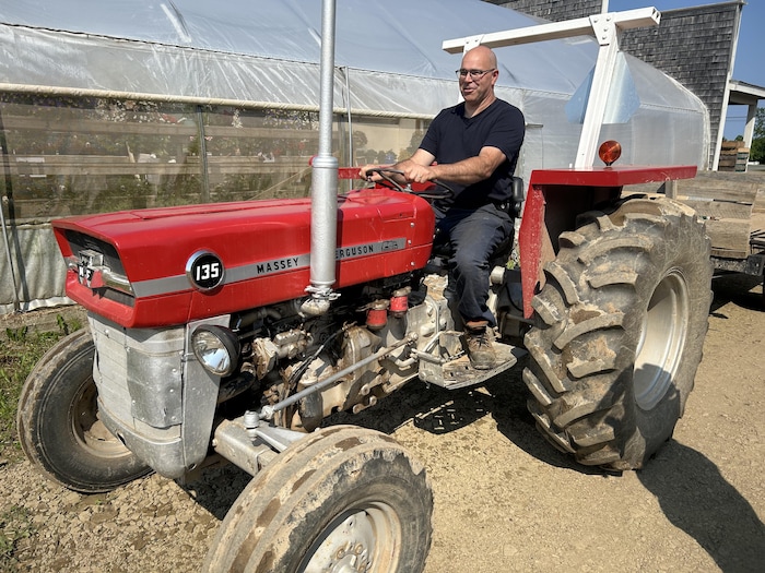 Un homme est assis sur un tracteur.