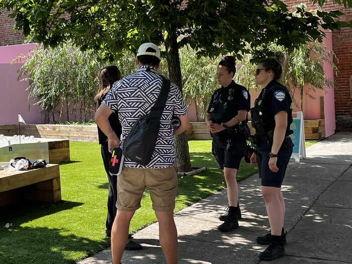 Des agentes ECCR et un intervenant psychosocial du CIUSSS abordent une itinérante qui consomme de l'alcool, sur la rue Sainte-Catherine.