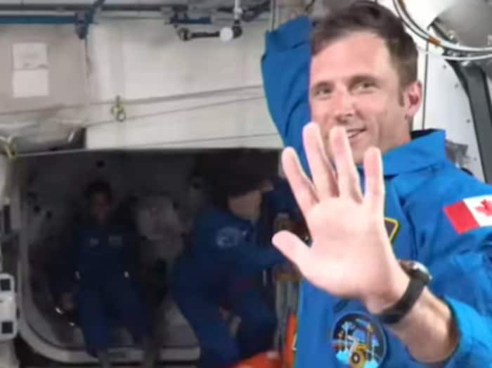 Joshua Kutryk faisant un signe de salutation avec la main gauche dans la SSI.