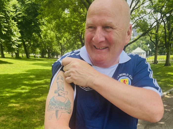 Kenny McAdam se dénude l'épaule pour nous montrer son tatouage Scotland, à l’encre verte.