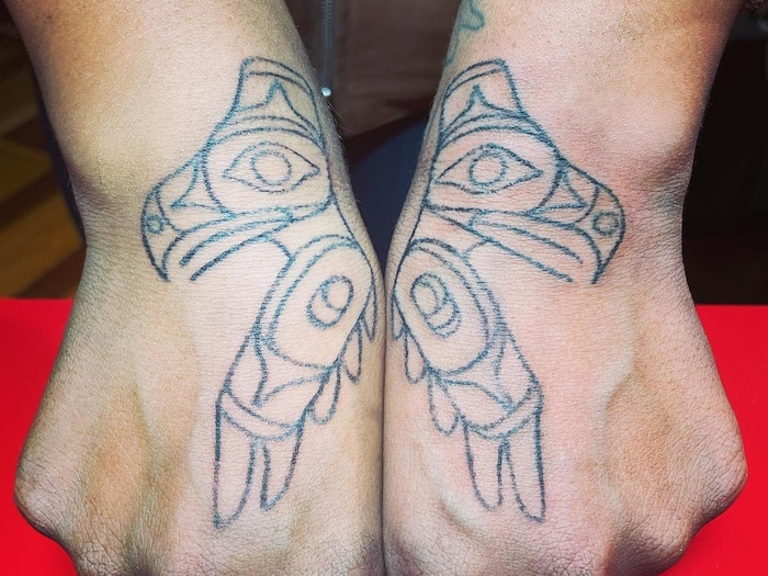 Deux têtes d'aigles tatouées sur le haut des mains.