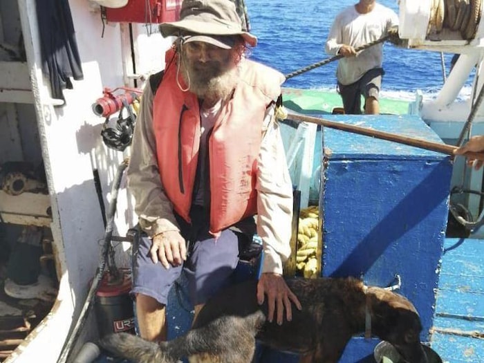 Tim Shaddock est assis dans le thonier qui l'a sauvé en compagnie de sa chienne Bella.