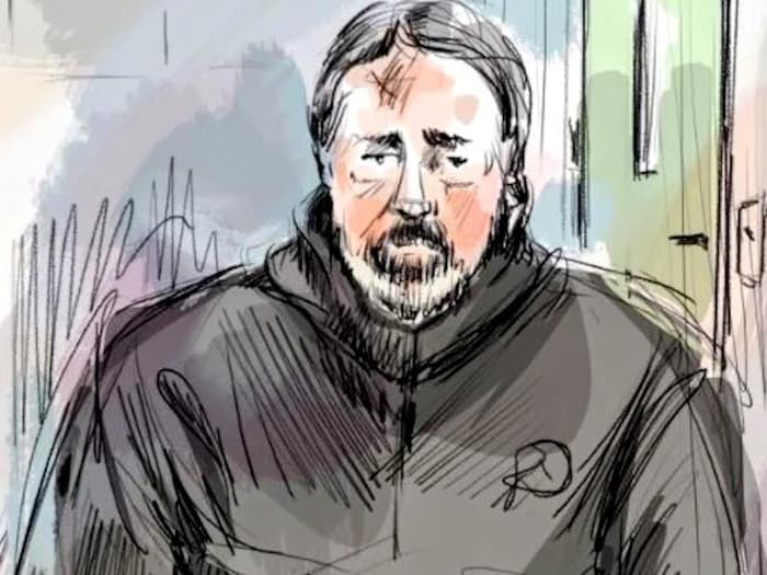 Croquis de Timothy Barnhardt aux cheveux foncés et à la barbiche, vêtu d’un chandail noir.