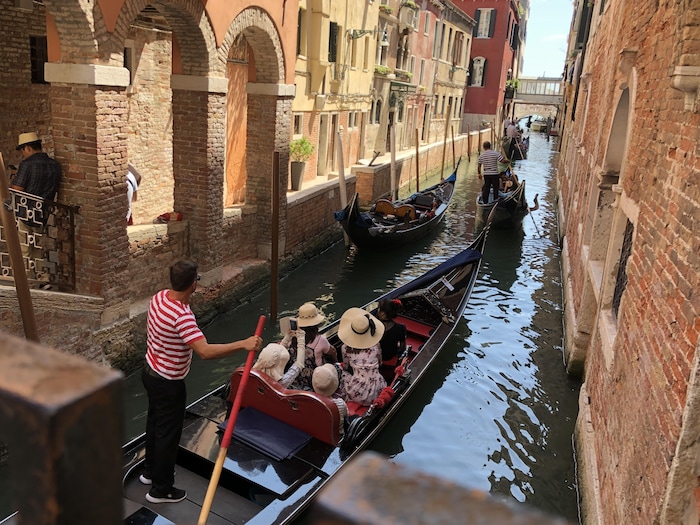Des gondoles longent des murs de briques dans un quartier de Venise.