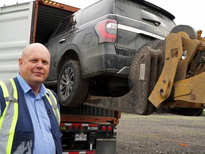 Un homme se tient aux côtés d'un véhicule.