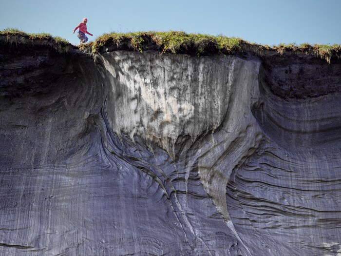Vue en contre-plongée d'une personne au bord d'une falaise.