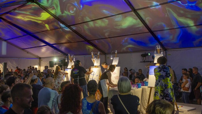 Des artistes sous un chapiteau coloré. 