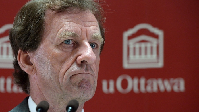 photographie d'Allan Rock avec le logo de l'Université d'Ottawa en arrière-plan