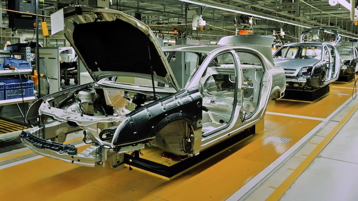 Des automobiles qui se font construire à la chaîne dans une usine.