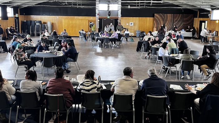 Des personnes assises dans une salle communautaire.