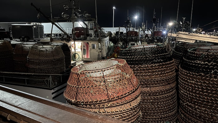 Sur un bateau, des pièges et de l'équipement pour la pêche au crabe des neiges.