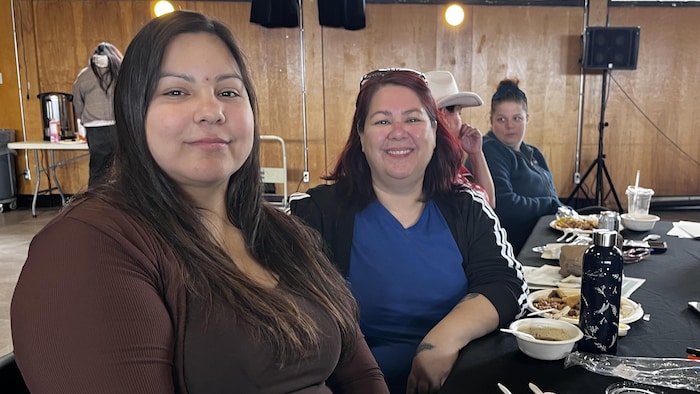 Deux femmes assises à table.