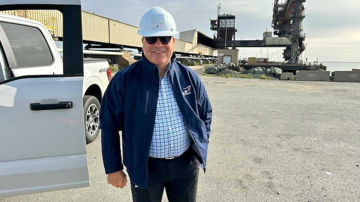 Denis Caron porte un casque, à proximité d'un camion, sur l'un des quais du port de Belledune.