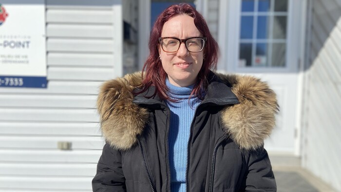 Marie-Ève Normand se tient debout devant le bâtiment du Centre d'intervention le Rond-Point.