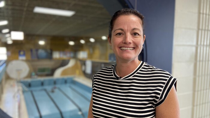 Martine Dufresne est devant une piscine.