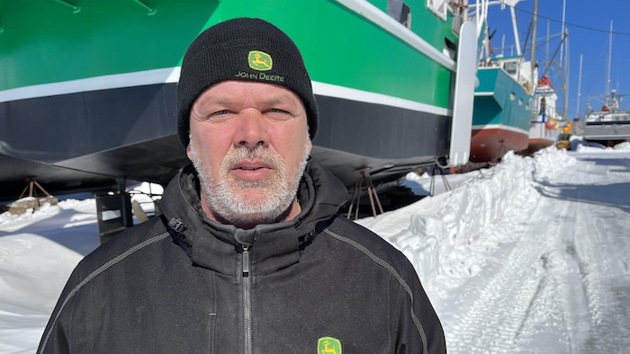 Paolo Gionet est devant un bateau.