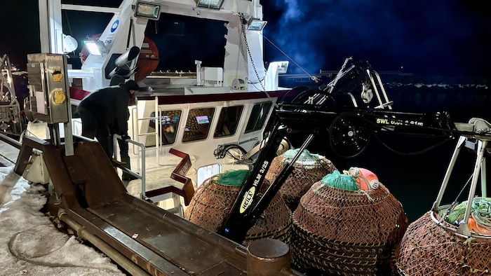 Des pêcheurs sont à pied d'œuvre pour préparer leur embarcation au quai de Sept-Îles.