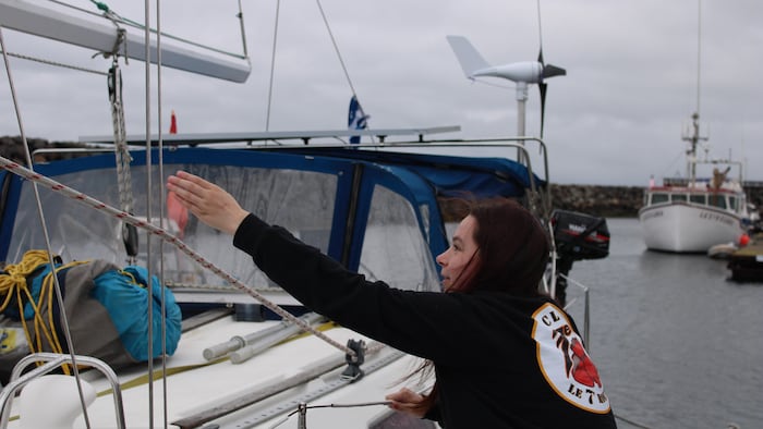 Une jeune femme sur le point d'embarquer sur un voilier.