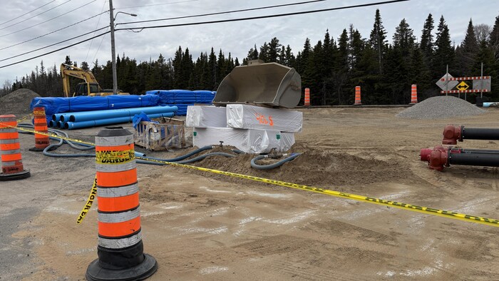Des tuyaux et des machines sur un chantier de construction.