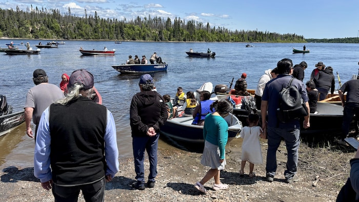 Des embarcations, sur l'eau, se dirigent vers une pourvoirie sur la rivière Moisie.