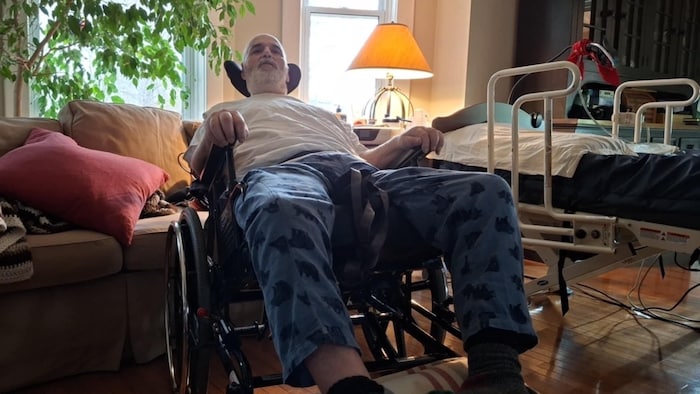 Un homme paralysé dans un fauteuil chez lui.