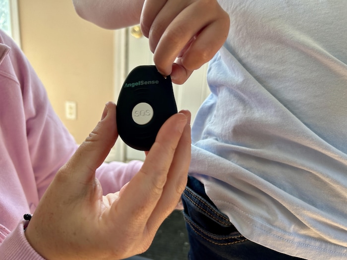 Karine Robichaud est sur le point d'accrocher l'appareil AngelSense sur le pantalon de son fils.