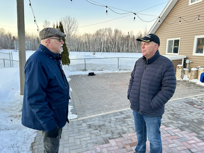 Donald Mallard et Patrice Godin discutent à l'extérieur, durant l'hiver.