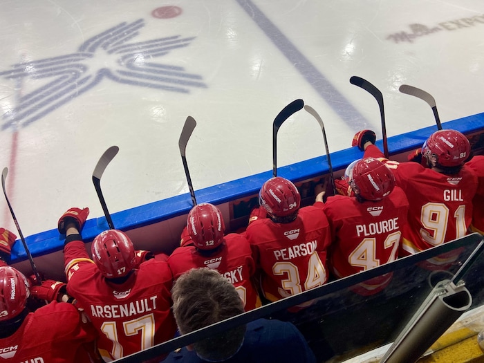Des joueurs de hockey attendent de pouvoir aller sur la glace.